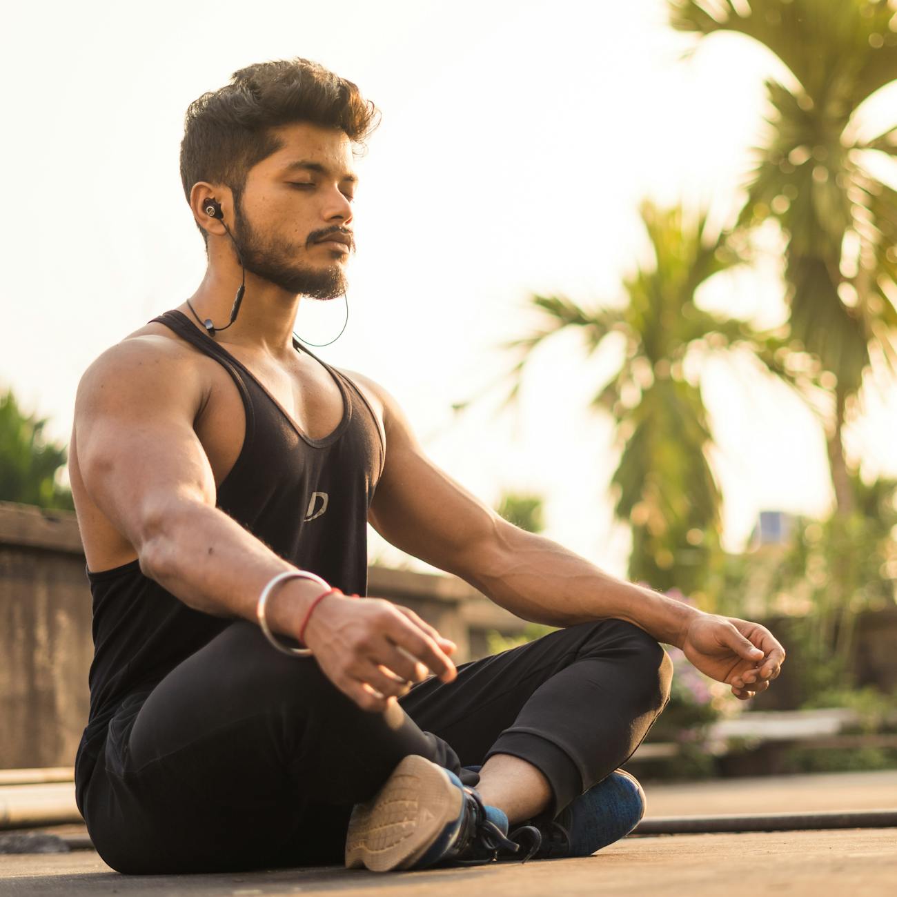 A young man practicing meditation outdoors at sunrise, capturing tranquility and focus.